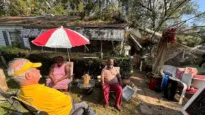 An Alabama Baptist Disaster Relief chaplain sitting with homeowners affected by Hurricane Helene in front of their damaged home.